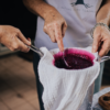picture of straining elderberry syrup through sieve lined with muslin