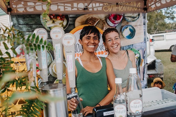 Photo from Sunny coast HerbFest stallholder in 2023. Image is two women smiling in Nourishing Wholefoods kombucha stall.