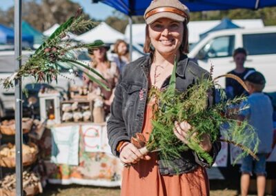 Image of woman smiling holding plants at HerbFest. HerbFest is the Sunshine Coast's annual herbal medicine community event. Everyday Empowered