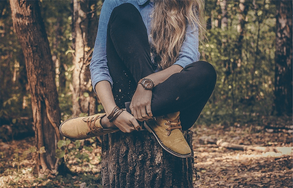 Herb Folk workshop - body detective, a Sunshine Coast herbal medicine workshop to learn self-diagnostics skills for home herbalists and people who want to care for themselves and family naturally. Image is of a woman sitting on a stump with legs crossed.