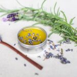 Herbal medicine-making: Salves. Herb Folk workshop on the Sunshine Coast, herbal medicine events and workshops. Image of lavender herbal salve with lavender scattered around and lavender stem.