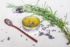 Herbal medicine-making: Salves. Herb Folk workshop on the Sunshine Coast, herbal medicine events and workshops. Image of lavender herbal salve with lavender scattered around and lavender stem.