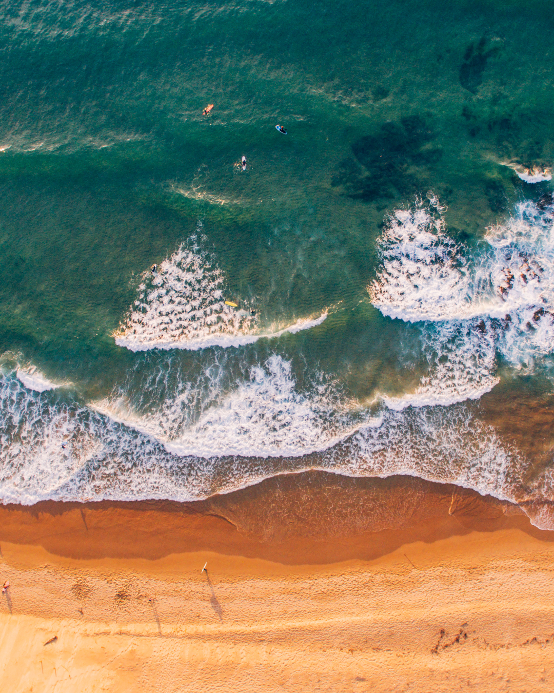 Image of beach from above, with waves and sand. Heatstroke: Symptoms, First Aid, and Prevention Tips