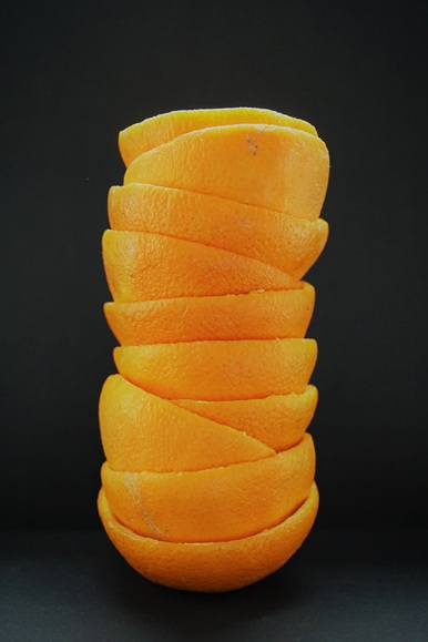 picture of orange peels piled up in a tower. Learn uses for citrus peel including kitchen remedies, home cleaning and more